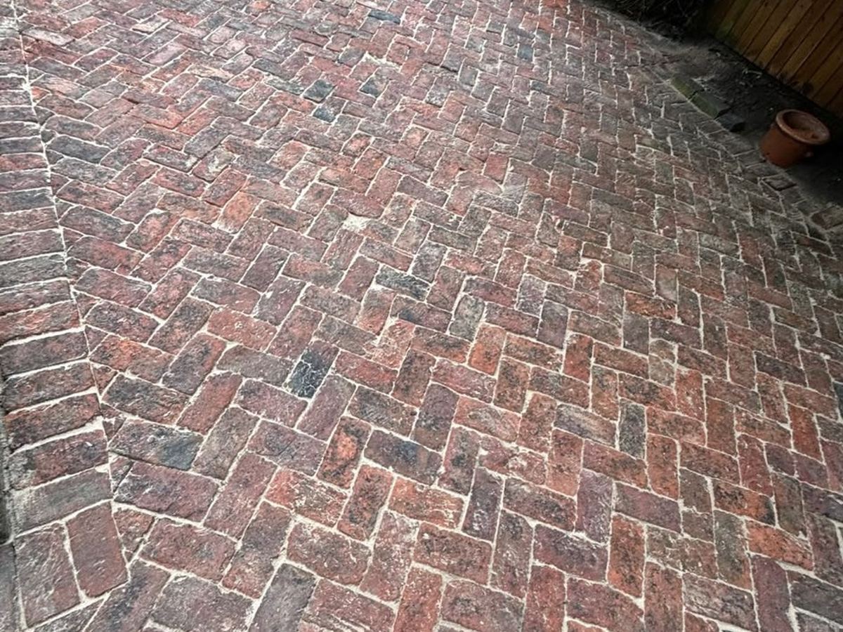 A brick paved driveway cleaned back to the brick