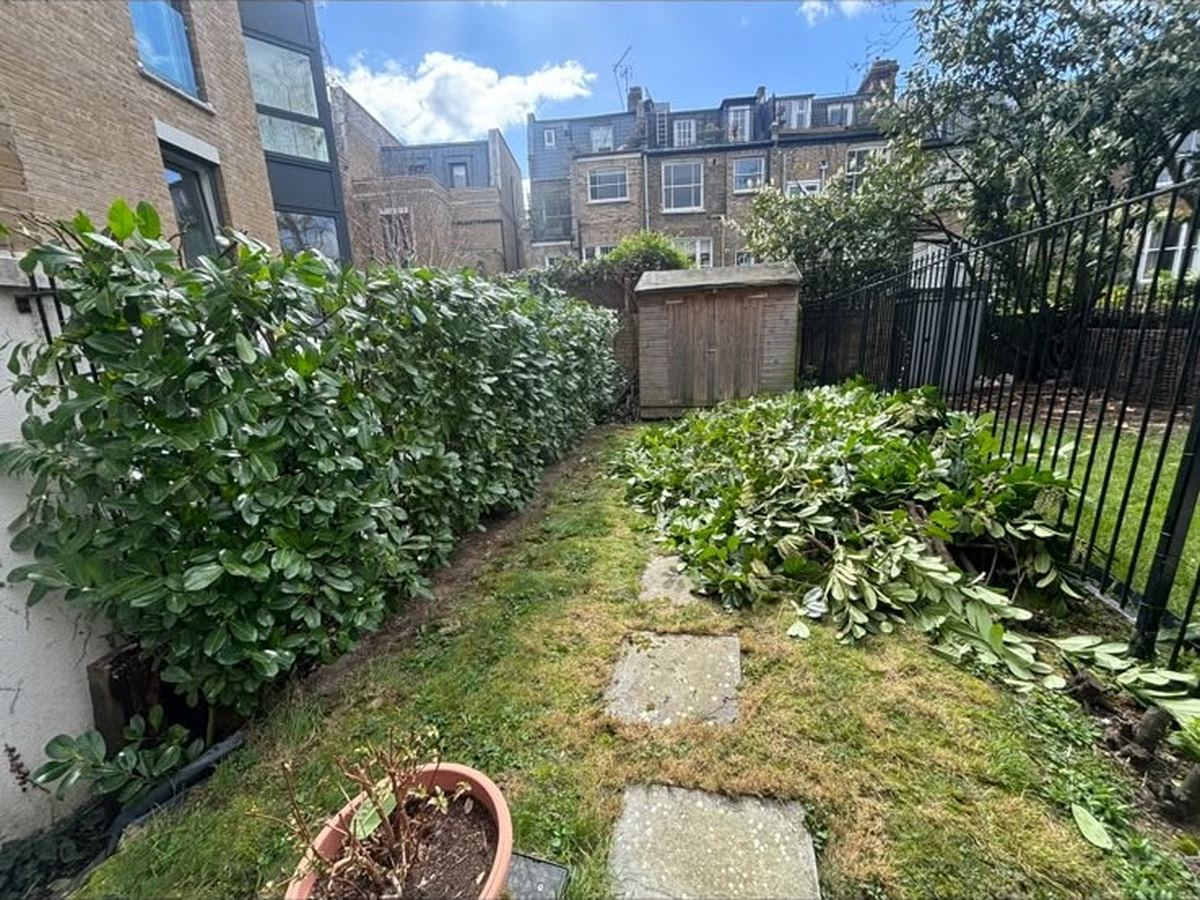 An overgrown side garden part way through clearance